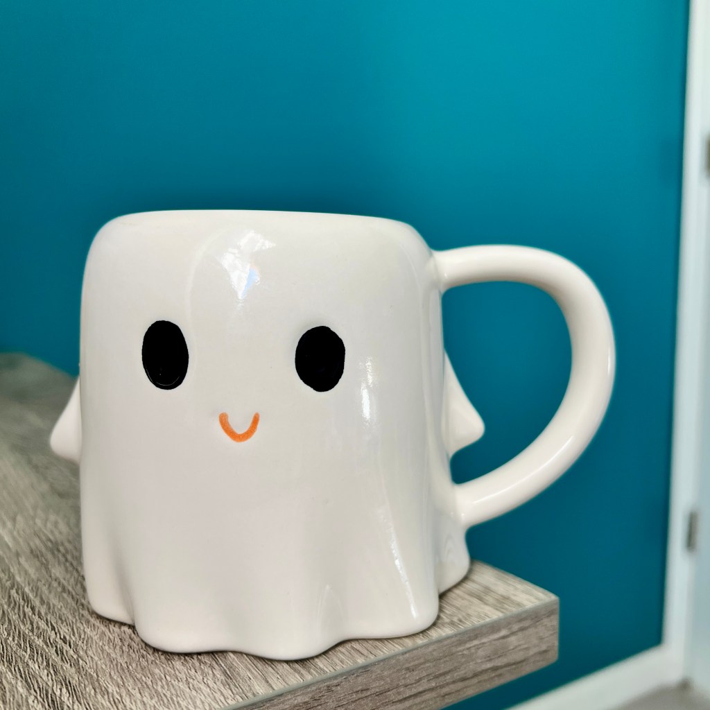 small white coffee mug that looks like a happy ghost with a tiny smile and big eyes